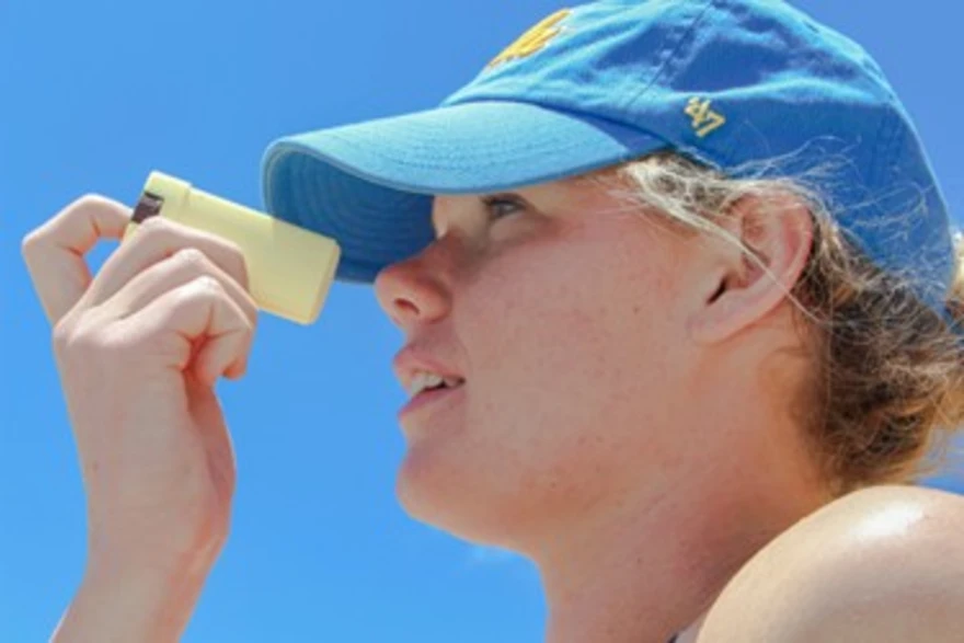 Sunscreen bottle with SPF label on a sunny beach background
